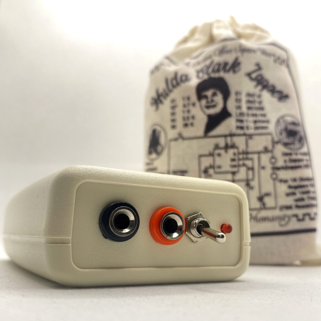 Hulda Clark Zapper with red/black leads, copper pipes, 9 volt battery, and canvas carry-all bag.